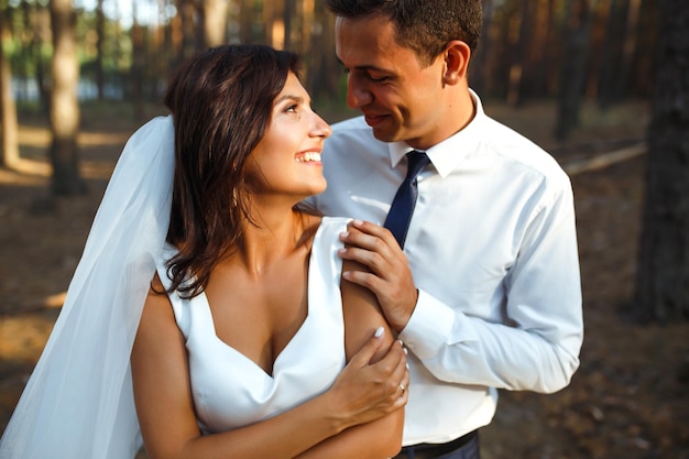 Happy newlywed couple of bride and groom are walking on nature in a green forest Wedding concept