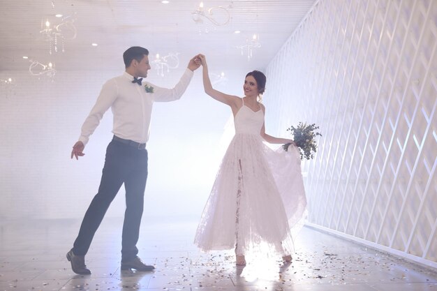 Happy newlywed couple dancing together in festive hall