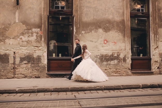 Happy newlyweds couple on a walk in old European town street