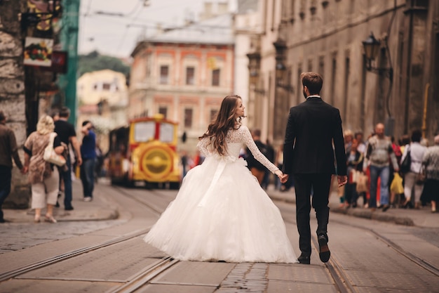 Happy newlyweds couple walking on the street