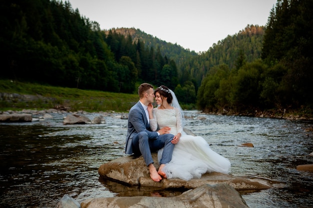 Happy newlyweds standing and smiling on the river . honeymooners, photo for valentine's day.