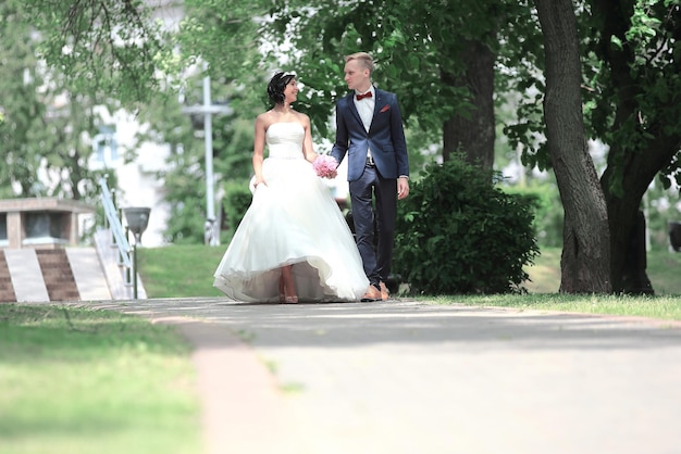 幸せな新婚夫婦がParkoutdoorsを歩きます