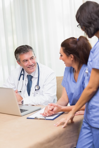 Happy nurses chatting with doctor