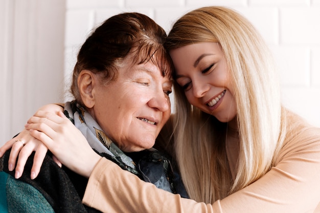 Happy old grandmother hugging grandchild smiling