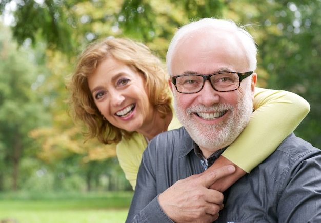 Happy older woman embracing smiling older man