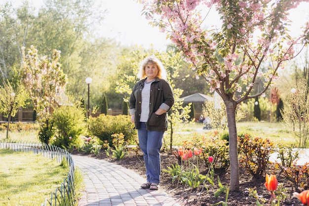 Happy older woman standing outside in summer