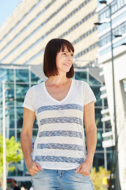 外に立っているストライプのTシャツで幸せな年上の女性