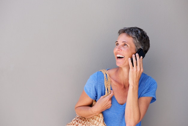 Happy older woman talking on cellphone 