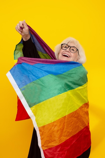 Happy older woman wrapped in lgtb rainbow flag