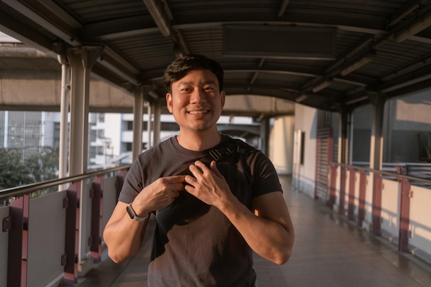 Happy ordinary man walk on the skytrain platform in bangkok