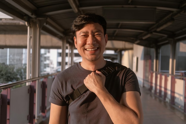 Счастливый обычный человек ходит по платформе воздушного поезда в Бангкоке
