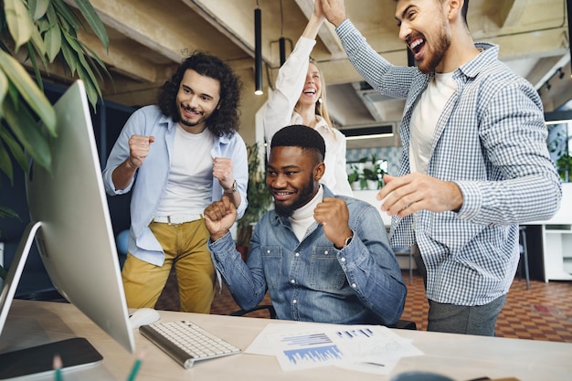 幸せな大喜びのビジネスチームは企業の勝利を祝います