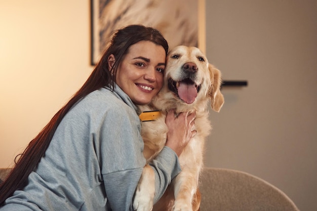 Happy owner of beautiful animal Woman is with golden retriever dog at home