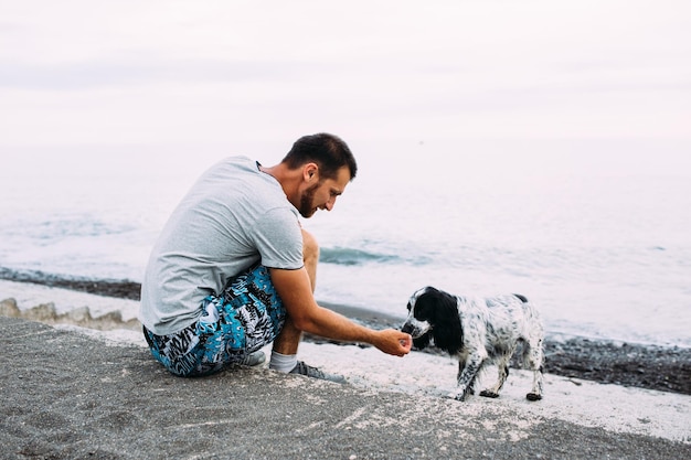 ペットの世話をするロシアのコッカースパニエル犬の責任の幸せな所有者