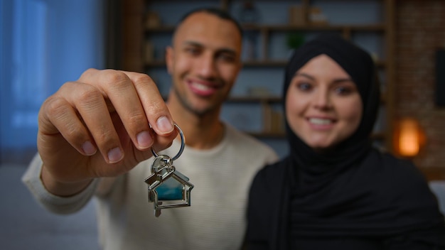 Happy owners property multiracial family spouses ethnic couple showing bunch of keys new home