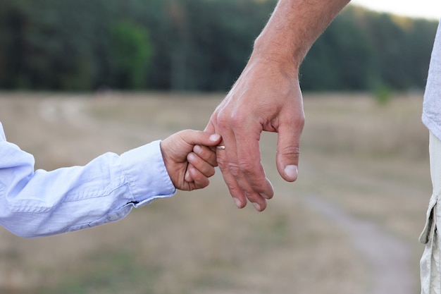 The happy parent holds the hand of a small child