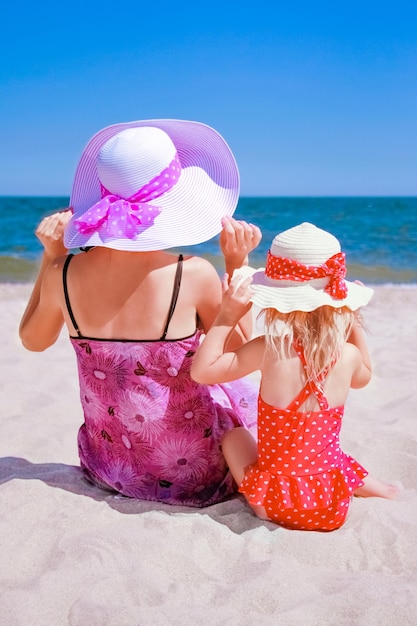 自然の夏の海で赤ちゃんと一緒に幸せな親母