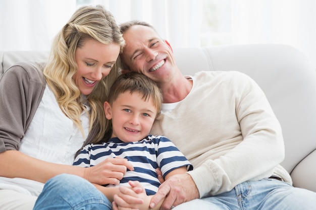 Happy parent tickling her cute son on the couch