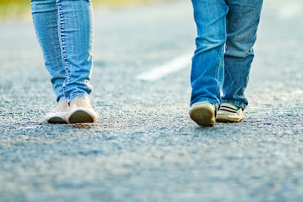 A Happy parent with child are walking along the road in the park on nature travel