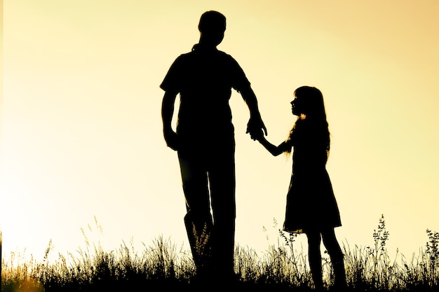 Photo happy parent with child in the park outdoors silhouette