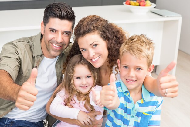 Photo happy parents giving thumbs up with their young children