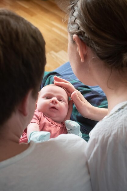 写真 生まれたばかりの赤ちゃんの女の子を抱いて幸せな両親