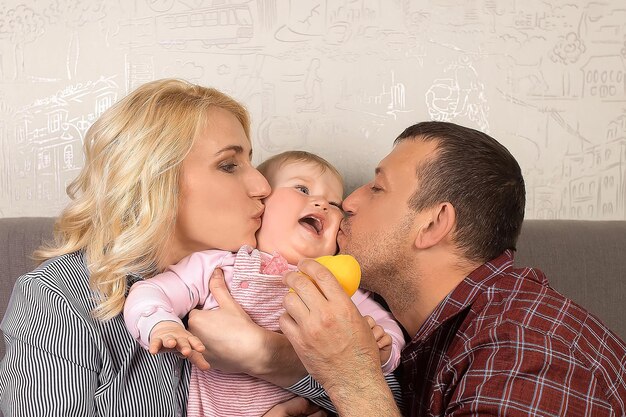 Happy parents kiss and play with their child Positive emotions Family life