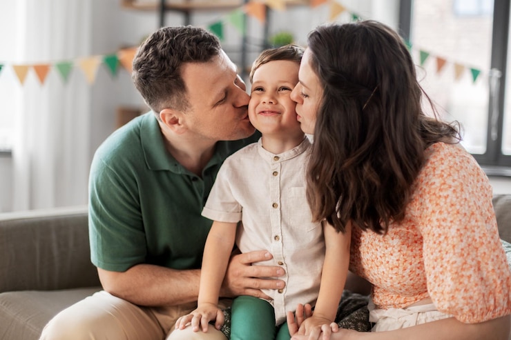 Photo happy parents kissing little son at birthday party