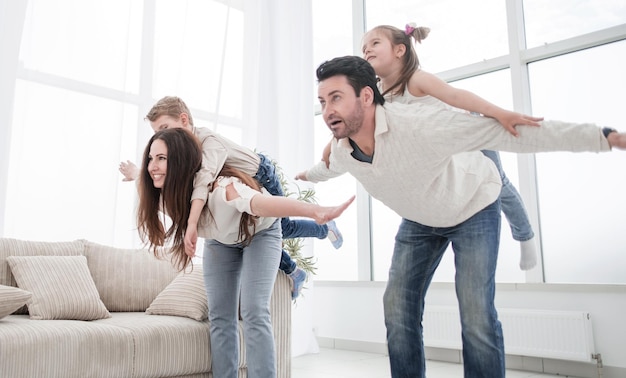 Happy parents play with children at homephoto with copy space