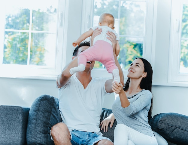 Happy parents playing with baby girl at home