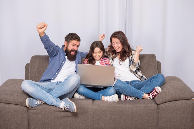 Happy parents with kid use pc at home family