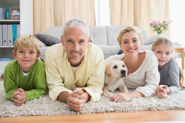 幸せな親、子どもと子犬を床に置いて