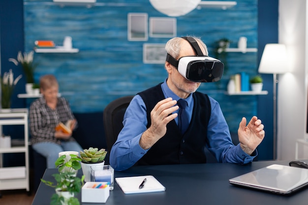 Happy pensioner experiencing virtual reality wearing headset