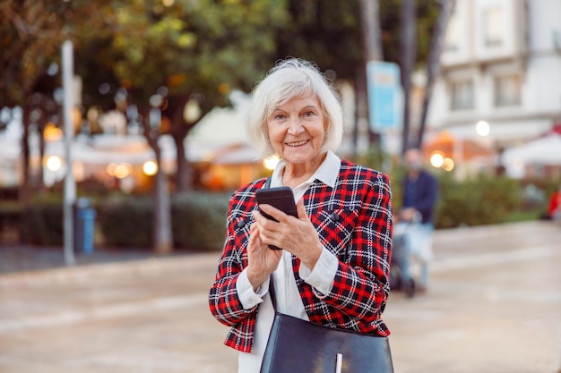 Happy pensioner female standing outdoors in town