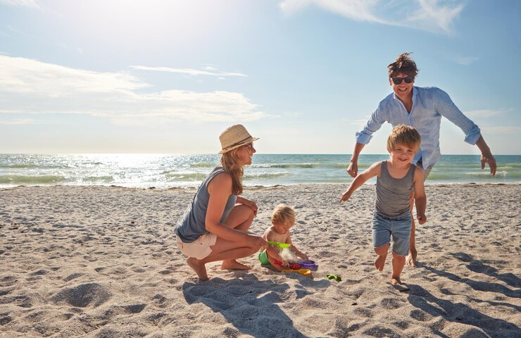 Photo happy people and children playing on the beach on family holiday vacation or adventure in summer boy father and kids with miami ocean for fun energy and happiness with running race chase game