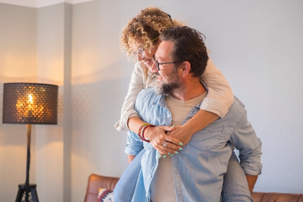 Foto la gente felice coppia uomo e donna sulle spalle si diverte e si gode insieme la casa sorridendo