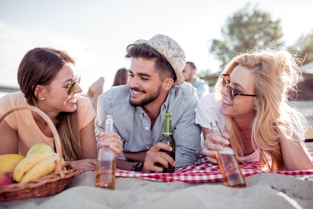 ビーチでビールを飲む幸せな人々