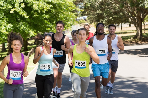 Happy people running race in park