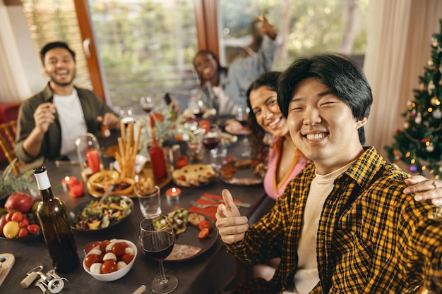 happy people taking selfie photo sitting on holiday dinner party at home and looks camera with smile