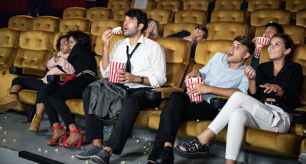 Gente felice che guarda film con godendo in teatro.