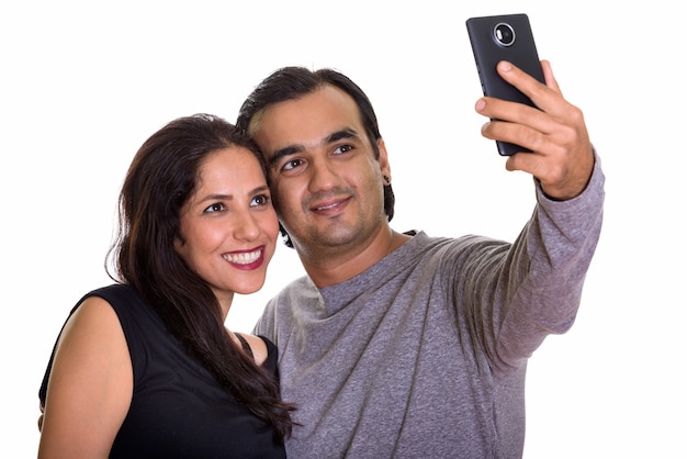 Happy Persian couple smiling while taking selfie picture