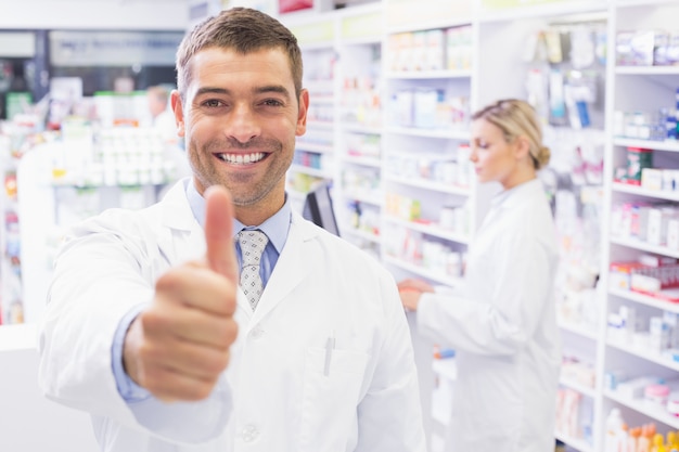 Happy pharmacist holding his thumb