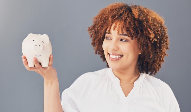 Happy piggy bank or black woman with savings budget or financial profits growth on studio background Smile finance or African American girl holding financial tin for cash loan or money investment