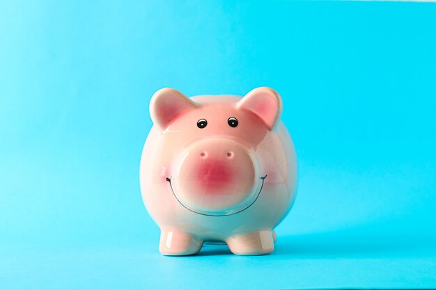 Happy piggy bank on color background