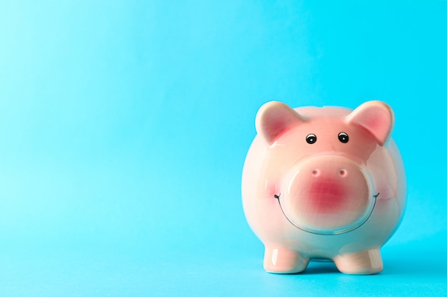 Happy piggy bank on color background