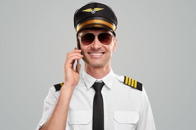 Happy pilot talking on smartphone