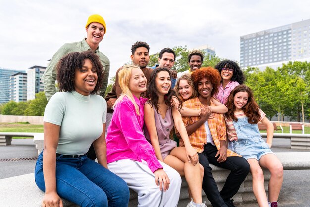 Happy playful multiethnic group of young friends bonding outdoors