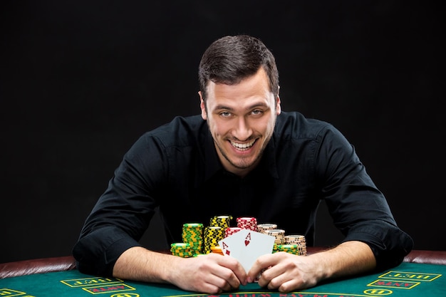 Photo happy poker player winning and holding a pair of aces