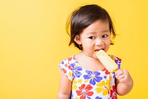 Happy portrait Asian baby or kid cute little girl eating ice cream, summer concept