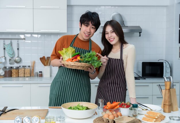 Happy portrait of loving young loving couple asian of having fun standing a cheerful preparing food